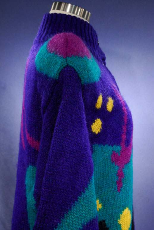 Woman's brightly colored knitted wool sweater-coat with desert motif and vibrant patterns