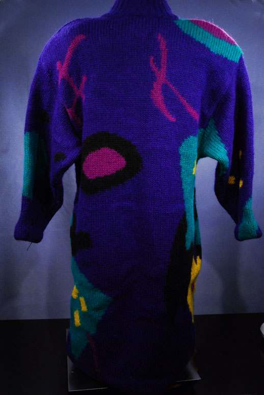 Woman's brightly colored desert motif wool sweater-coat with bold purple, teal, pink, and yellow patterns