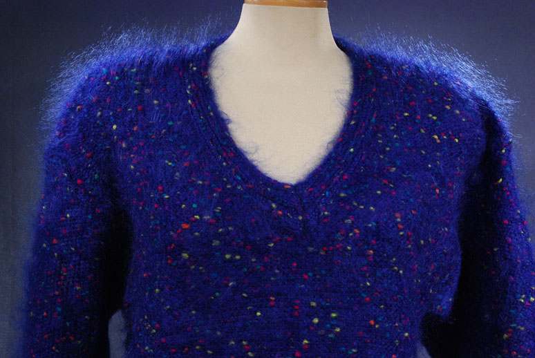 Woman's blue speckled mohair V-neck sweater with red, green, yellow, and blue knit-in specks, size small-medium