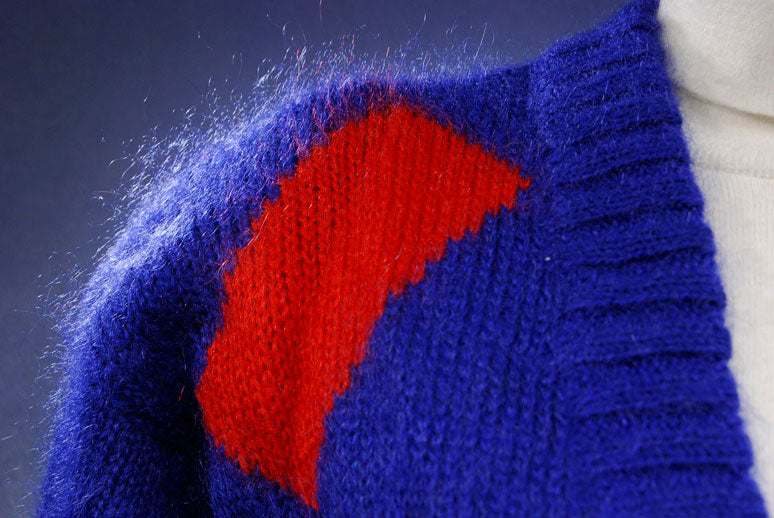 Woman's colorful deep V-neck sweater with red and blue geometric design by Nell Flowers