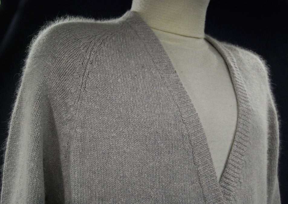 Woman's grey silk-angora cardigan sweater with pearl buttons on mannequin