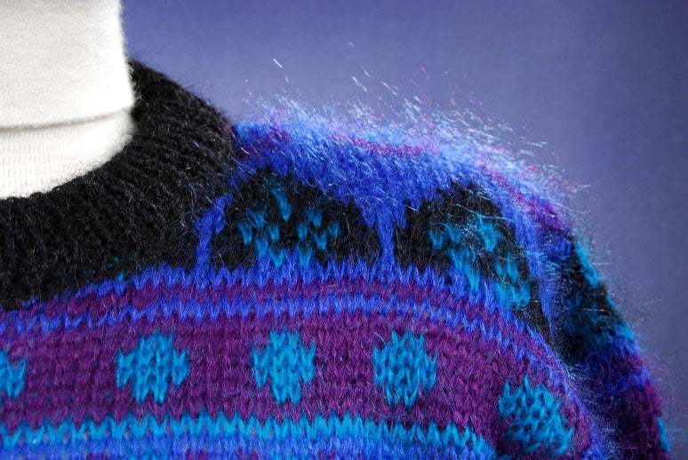Close-up of woman's blue multi-colored retro mohair crewneck sweater with black trim by Gallagher