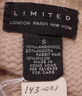 Close-up of a woman's pink angora sweater label by The Limited showing fabric composition and size small.