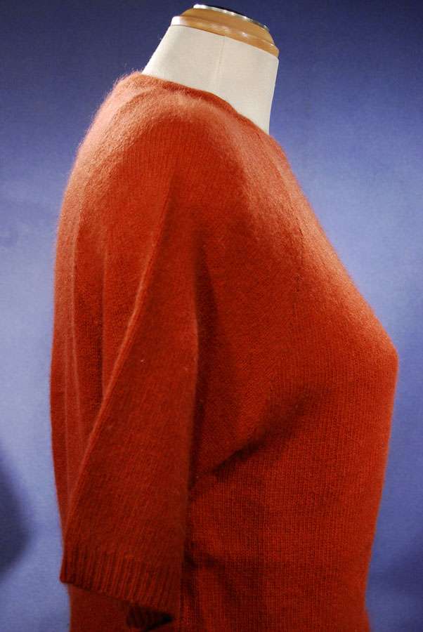 Woman's burnt-orange short-sleeved angora sweater by Claud Vernet on mannequin