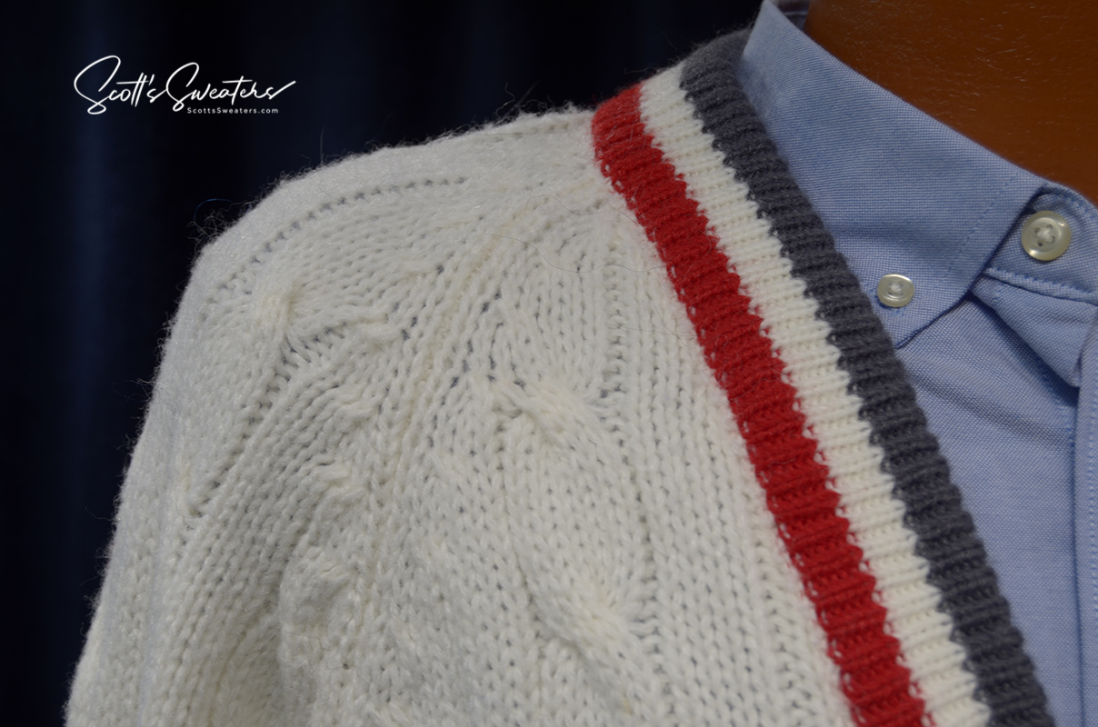 Men's classic retro Izod cardigan tennis sweater with red, white, and gray striped trim and cable knit pattern.