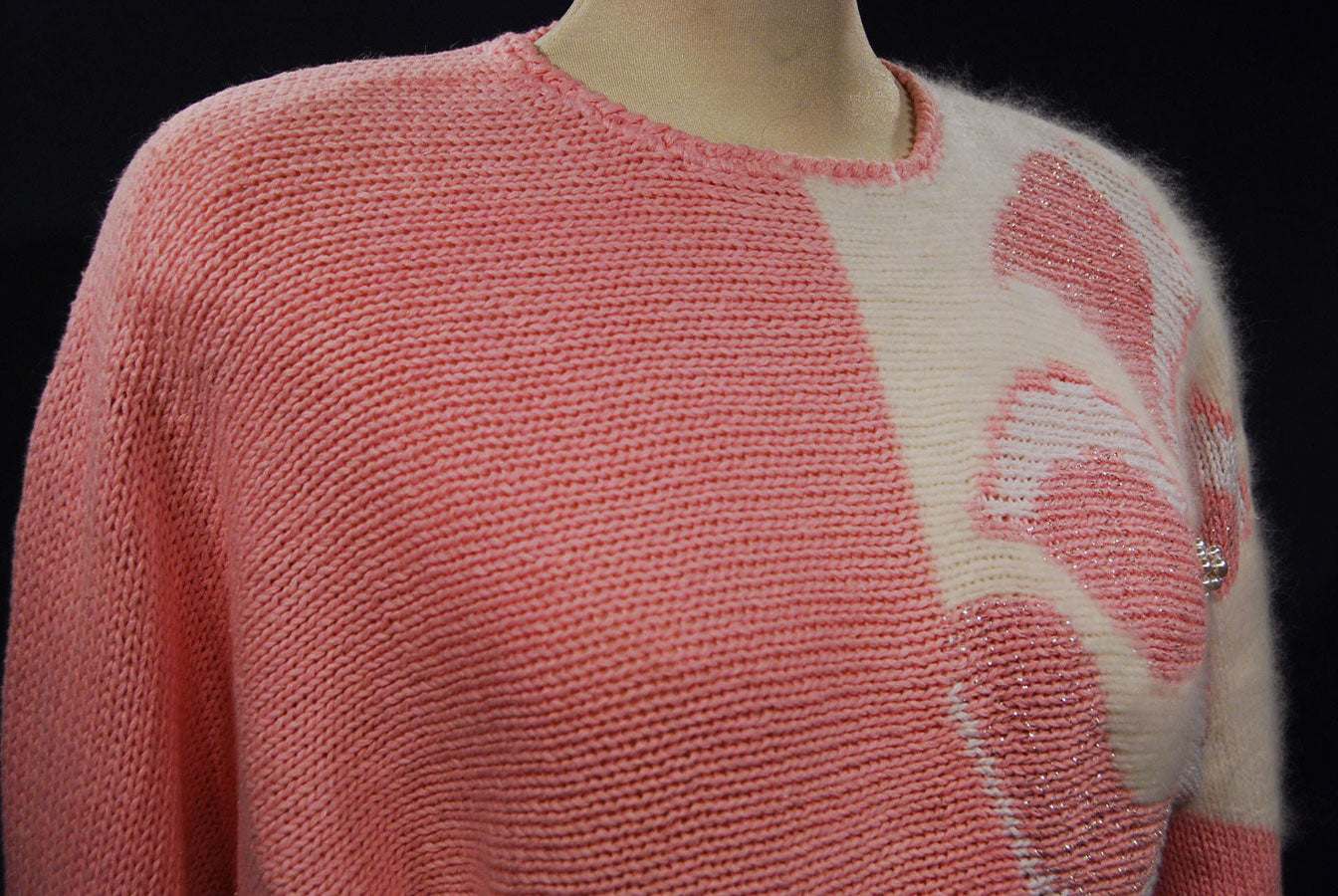 Woman's pink angora sweater with white beaded floral design on left shoulder by David Brett, size 36.