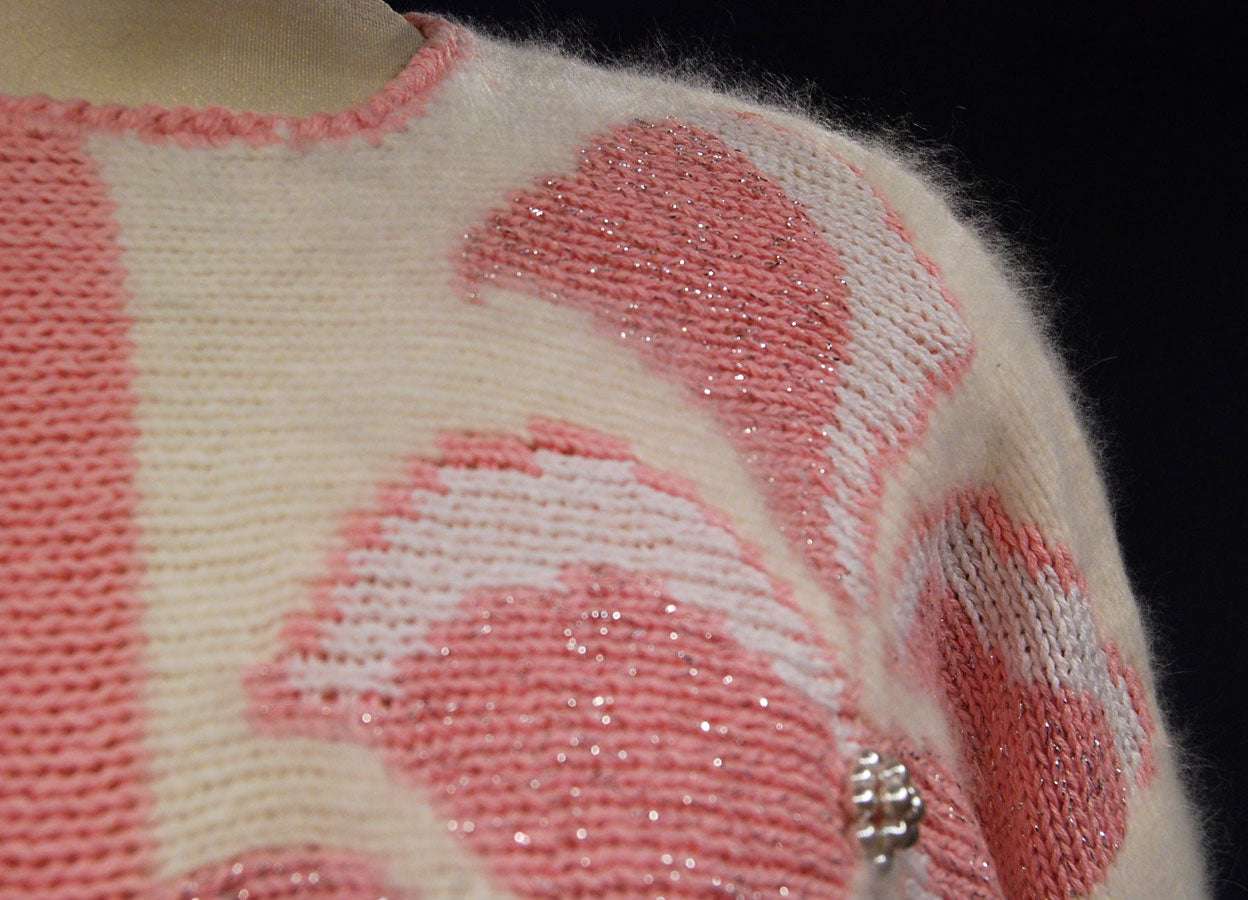 Close-up of woman's beaded-pink angora sweater with white and pink bead design on left shoulder by David Brett, size 36