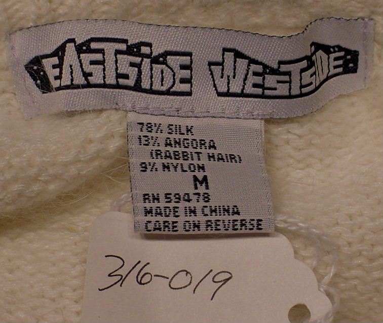 Label of teen girl's cropped zipper-front silk-angora cardigan sweater by Eastside Westside in medium size showing fabric composition and care instructions
