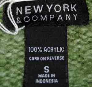 Close-up of a woman's sage-green V-neck sweater label from New York & Company, size small, made of 100% acrylic.