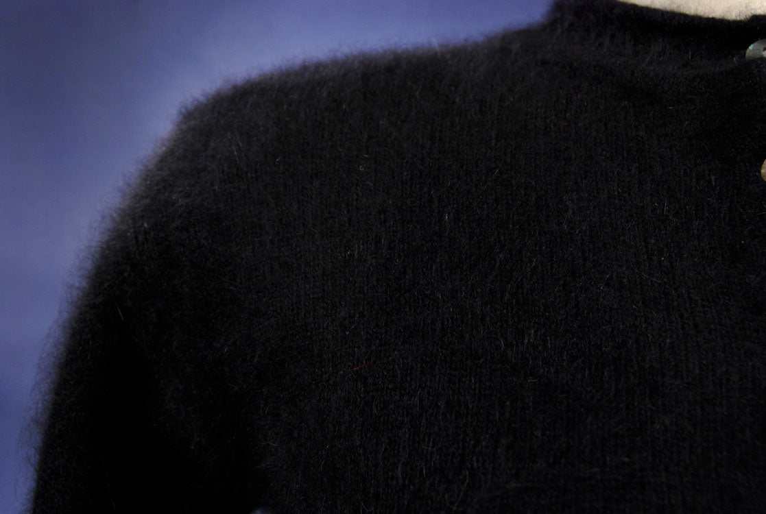 Close-up of woman's black angora cardigan sweater by Express Tricot in X-small size with button-front and round neck.