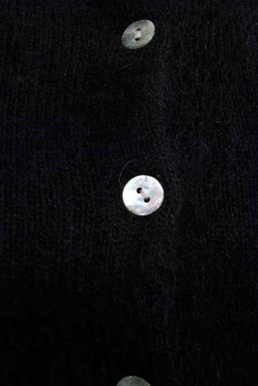 Close-up of black angora cardigan sweater with white buttons by Express Tricot in X-small size