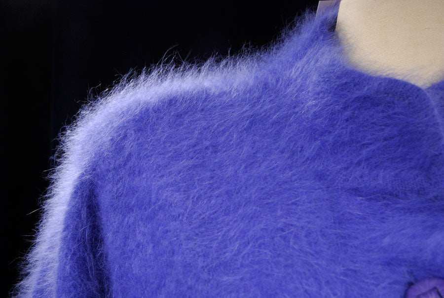 Close-up of woman's powder-blue angora cardigan sweater by Venesha with soft fluffy texture