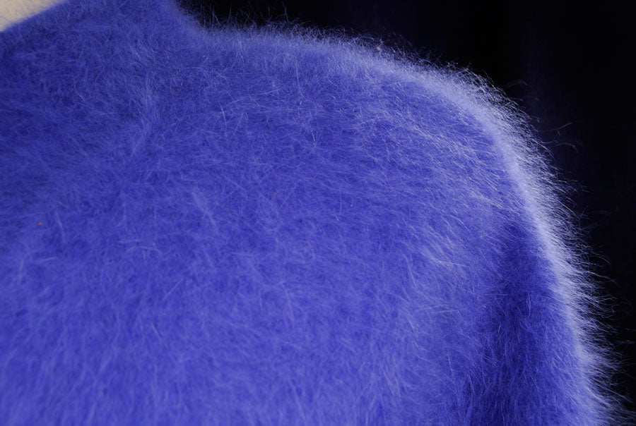 Woman's powder-blue angora cardigan sweater close-up showing soft fuzzy texture
