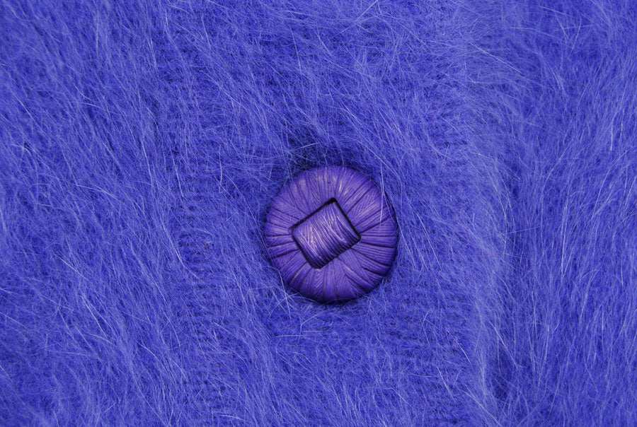 Close-up of woman's powder-blue angora cardigan sweater button by Venesha