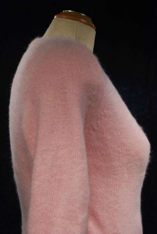Woman's pink angora-lambswool crossover pullover sweater with side buttons on mannequin