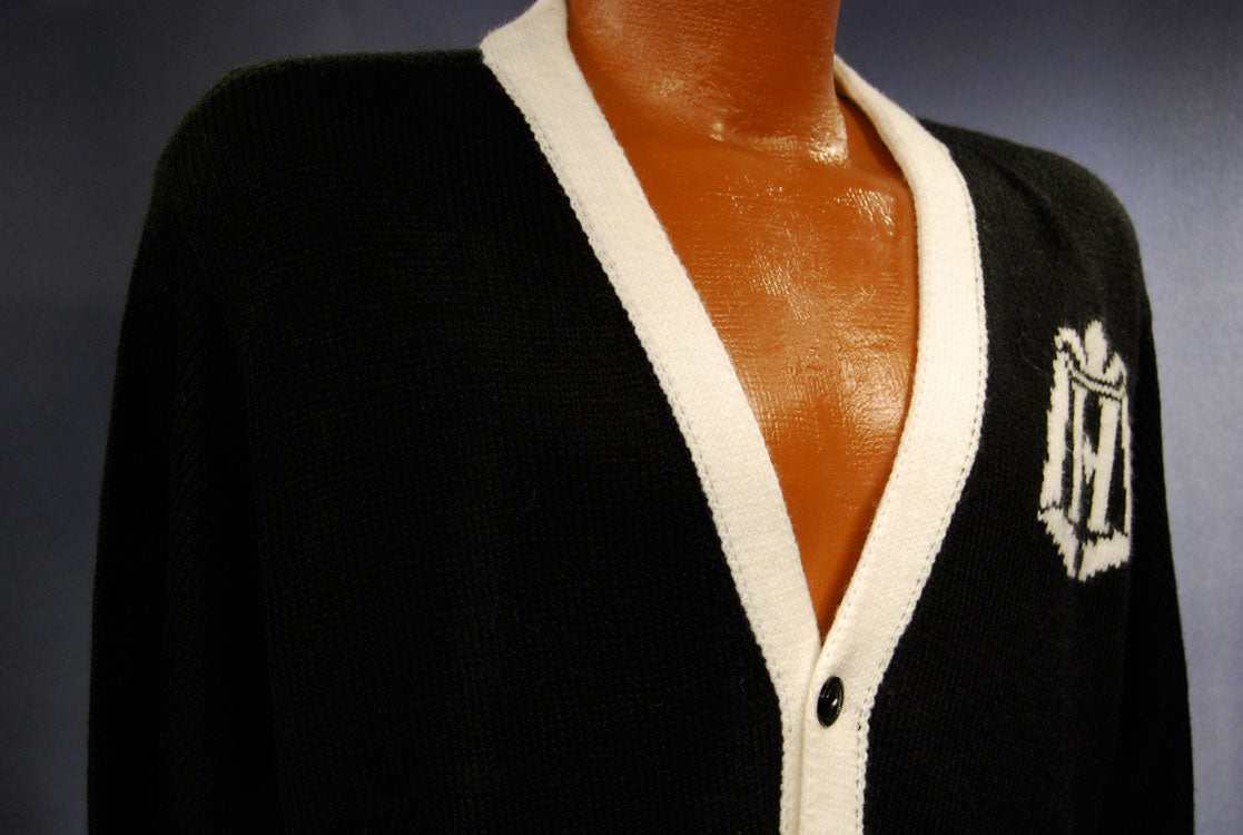 Woman's black cardigan tennis sweater with white trim and logo on front by Knitter-bug Studio