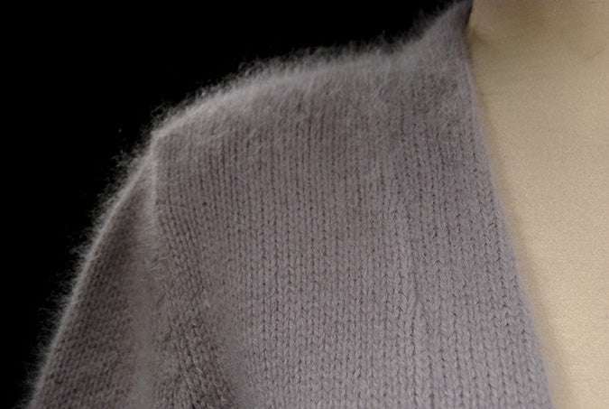 Close-up of soft grey woman's angora shrug cardigan with open front and three-quarter sleeves