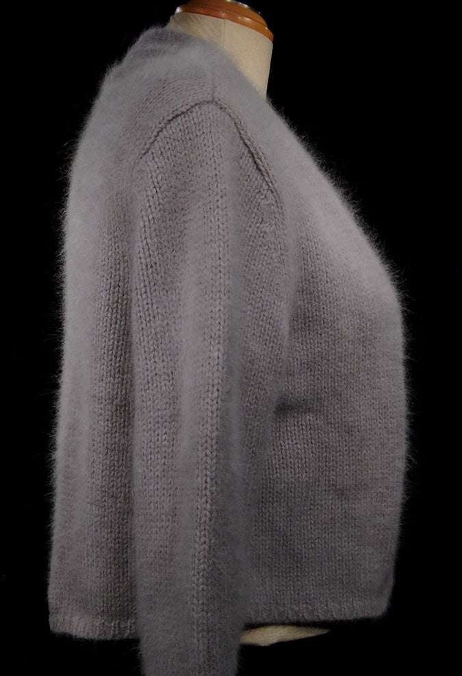 Soft gray woman's angora shrug cardigan sweater with open front and three-quarter sleeves on mannequin