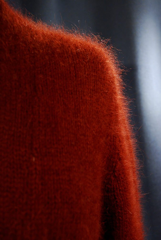 Close-up of soft red angora shrug cardigan sweater fabric texture