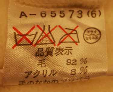 Care label showing fabric composition of 92% wool and 8% acrylic for Woman's Fancy White Angora Sweater.