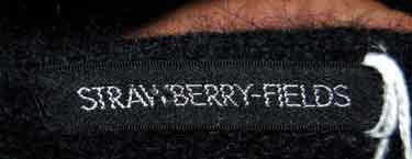 Close-up of Strawberry-Fields label on woman's black angora cardigan sweater with unique hook and loop closures, size XX-Small