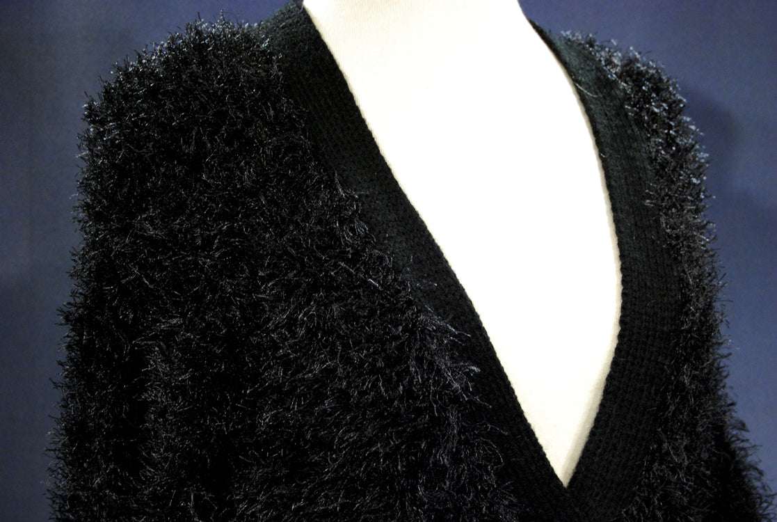 Black woman's eyelash cardigan sweater with long fuzzy acrylic fibers and deep V-neck on mannequin