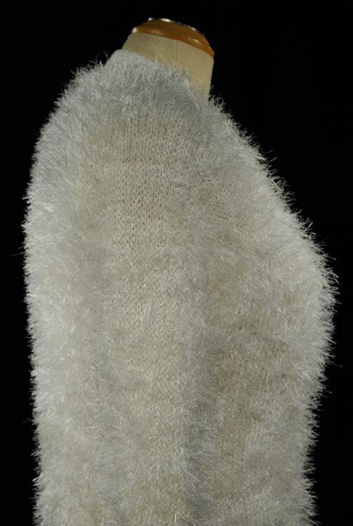 Woman's eyelash cardigan sweater in light gray fuzzy acrylic fibers with four buttons and front pockets displayed on mannequin.