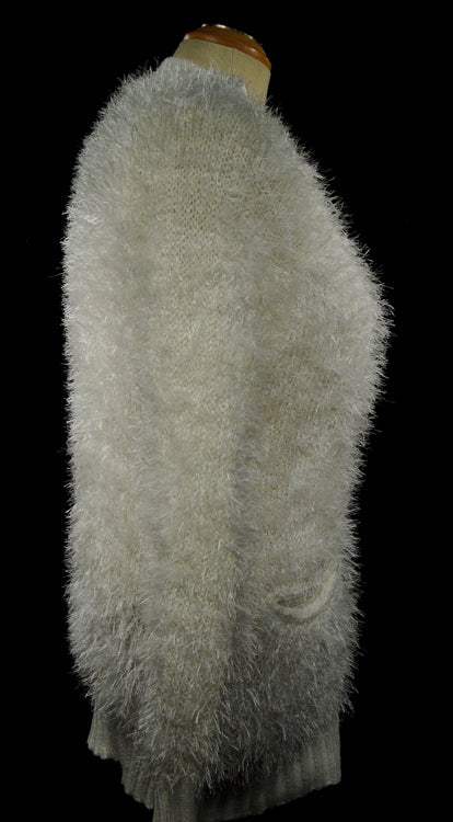 Woman's eyelash cardigan sweater with long fuzzy acrylic fibers and front pockets in light gray color.