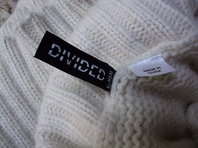 Close-up of ivory sleeveless angora-lambswool cable-knit sweaterdress label by H&M Divided, size 8, made in China