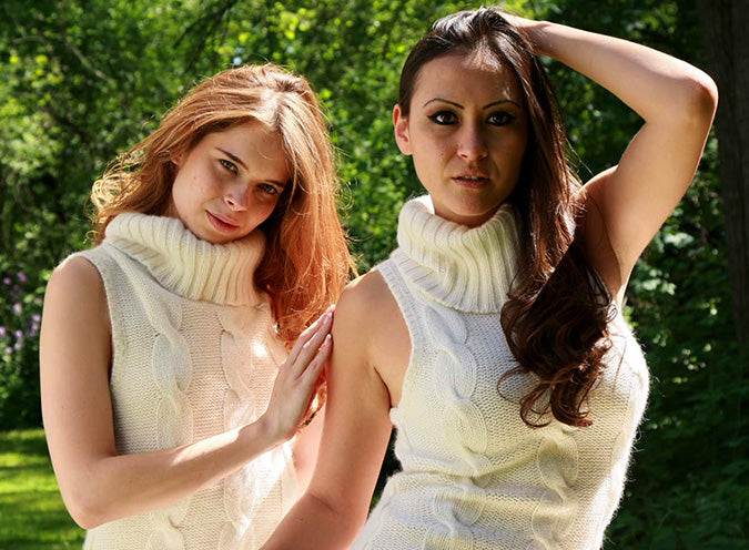 Two women wearing ivory sleeveless angora sleeveless turtleneck cable-knit sweaterdresses outdoors