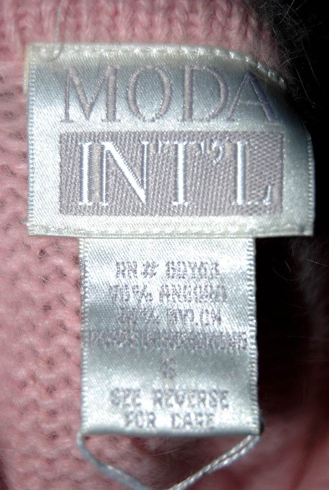 Close-up of Moda Intl label on pink angora cropped polo-neck sweater