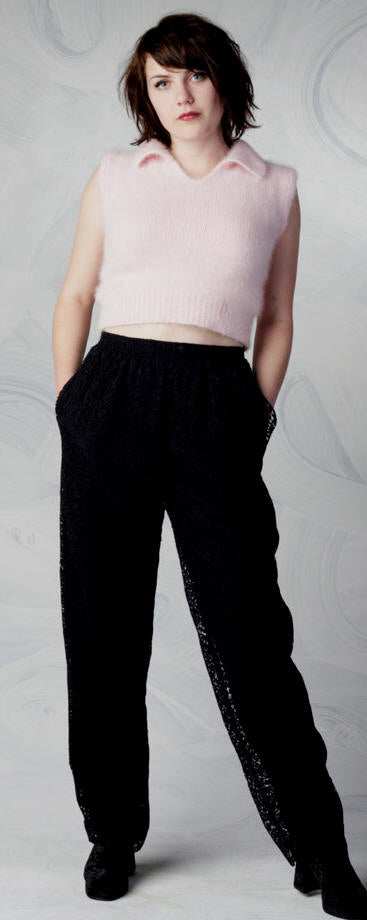 Woman wearing pink angora cropped polo-neck sweater with sheered-off sleeves by Moda Intl