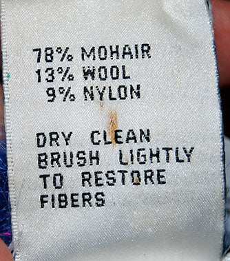 Care label showing fabric content and care instructions for woman's blue speckled mohair sweater