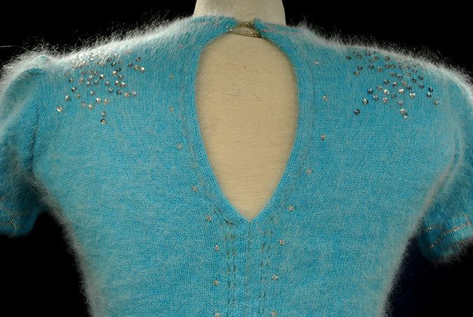 Close-up of aqua angora sweater with rhinestone embellishments and keyhole neckline from a woman's two-piece matching set