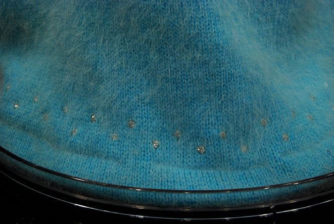 Close-up of aqua angora sweater skirt hem with rhinestone trim from woman's two-piece matching outfit
