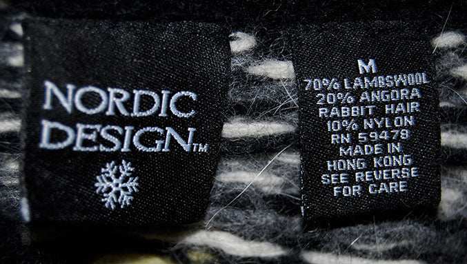Close-up of Nordic Design sweater label on woman's black and yellow angora turtleneck sweater medium size