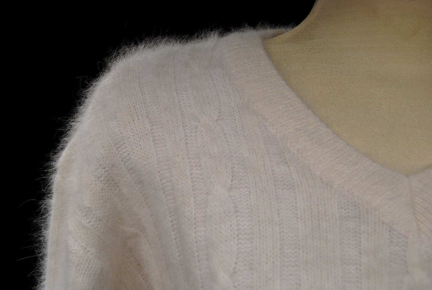 Woman's white angora rib-knit V-neck sweater close-up on mannequin