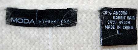 Close-up of Moda International label on woman's white angora cardigan sweater made of 65% angora rabbit hair and 35% nylon