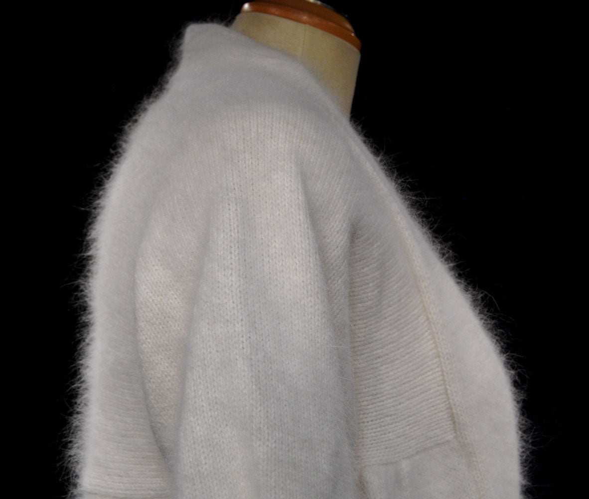 Woman's white angora open-front shrug cardigan sweater on mannequin