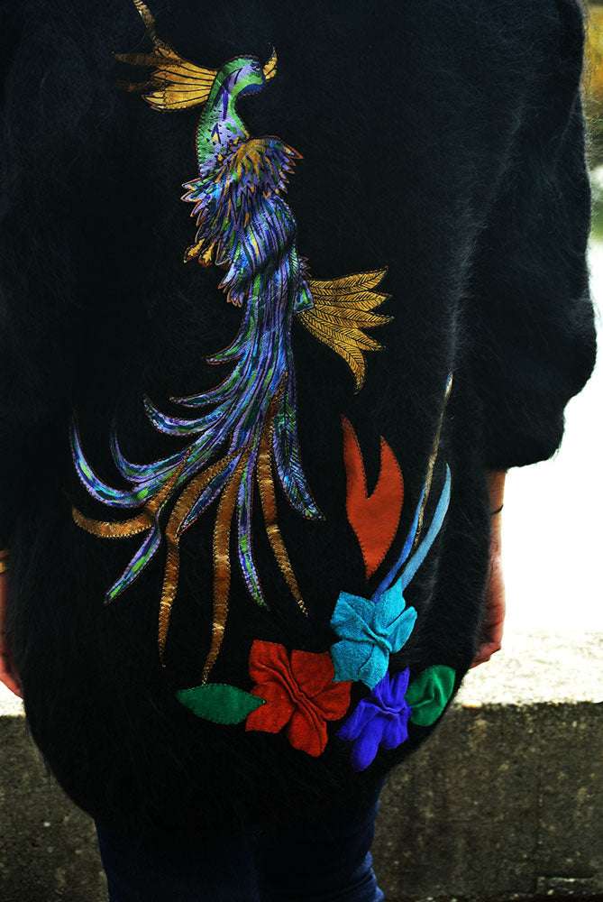 Woman's black angora cardigan sweater with large colorful peacock embroidery on back and floral design
