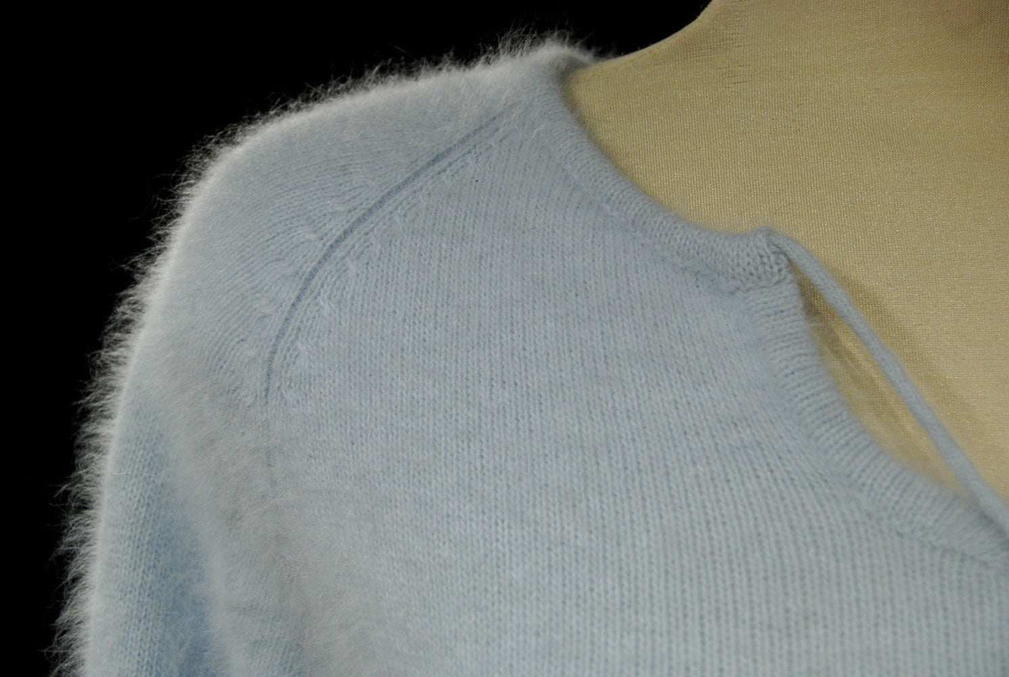 Powder blue woman's angora tie-neck sweater with soft fuzzy texture and subtle striped design