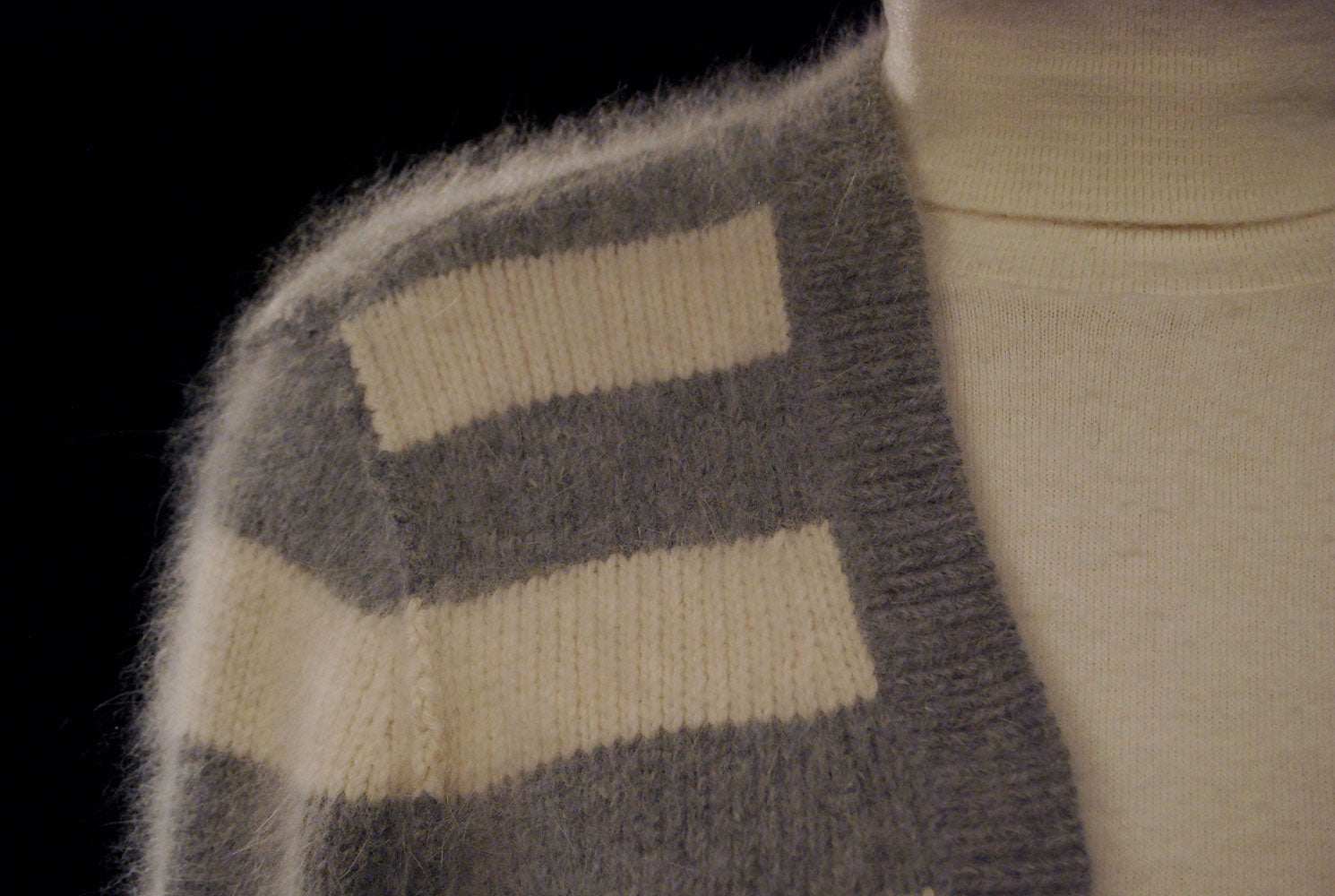 Close-up of woman's grey and white striped angora cardigan sweater by PINK with soft fuzzy texture and front pockets