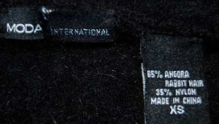 Woman's black angora wool cardigan sweater label showing fabric composition and size XS