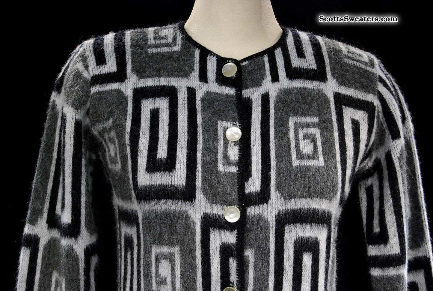 Woman's retro Mad Men's era faux mohair cardigan sweater with black, white, and grey geometric swirl pattern and pearl buttons