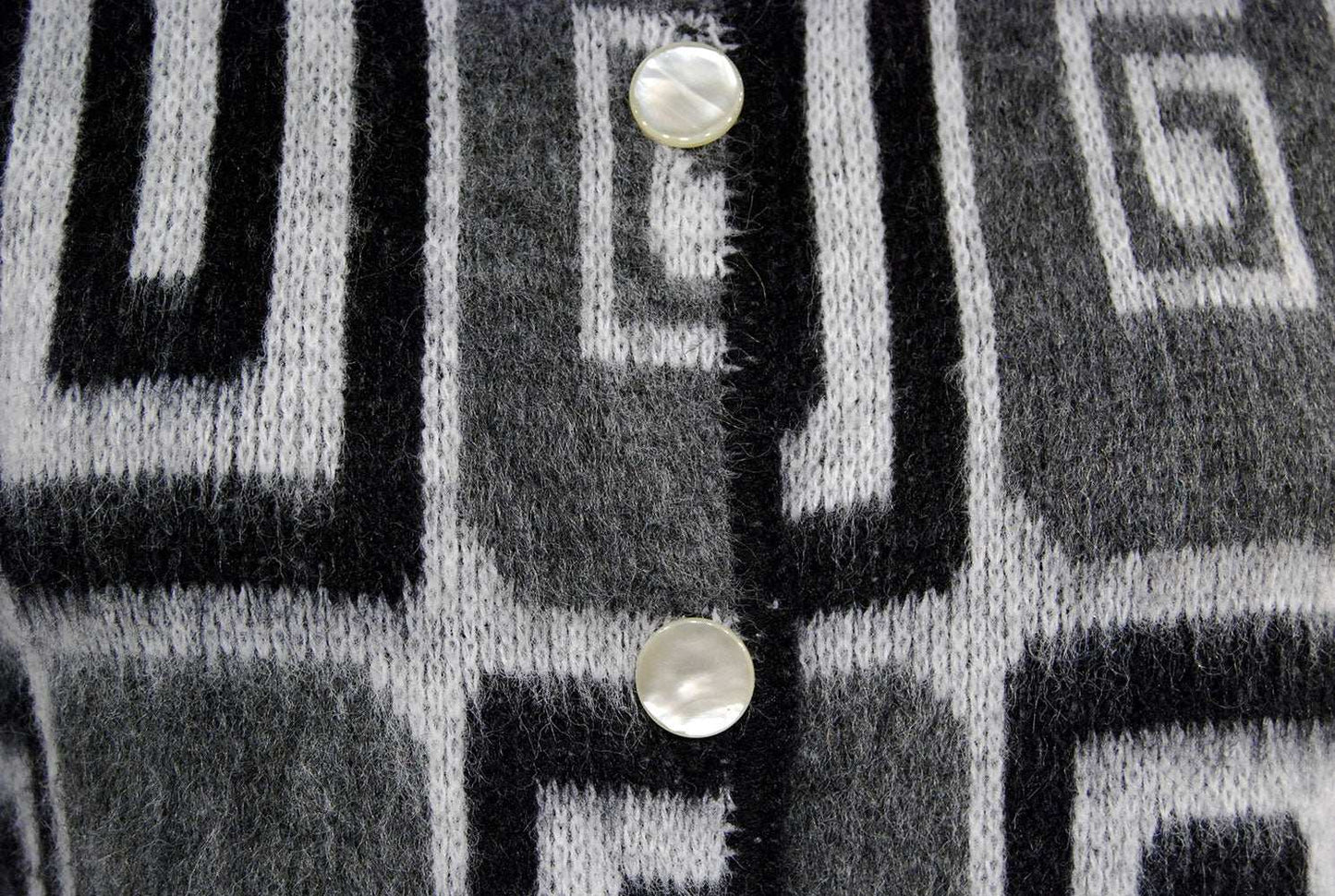 Woman's retro Mad Men's era black white grey faux mohair cardigan sweater with geometric swirl pop-art design and pearl buttons