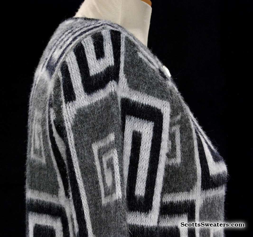 Woman's retro Mad Men's era faux mohair cardigan sweater in black, white, and grey with geometric swirl pop-art design