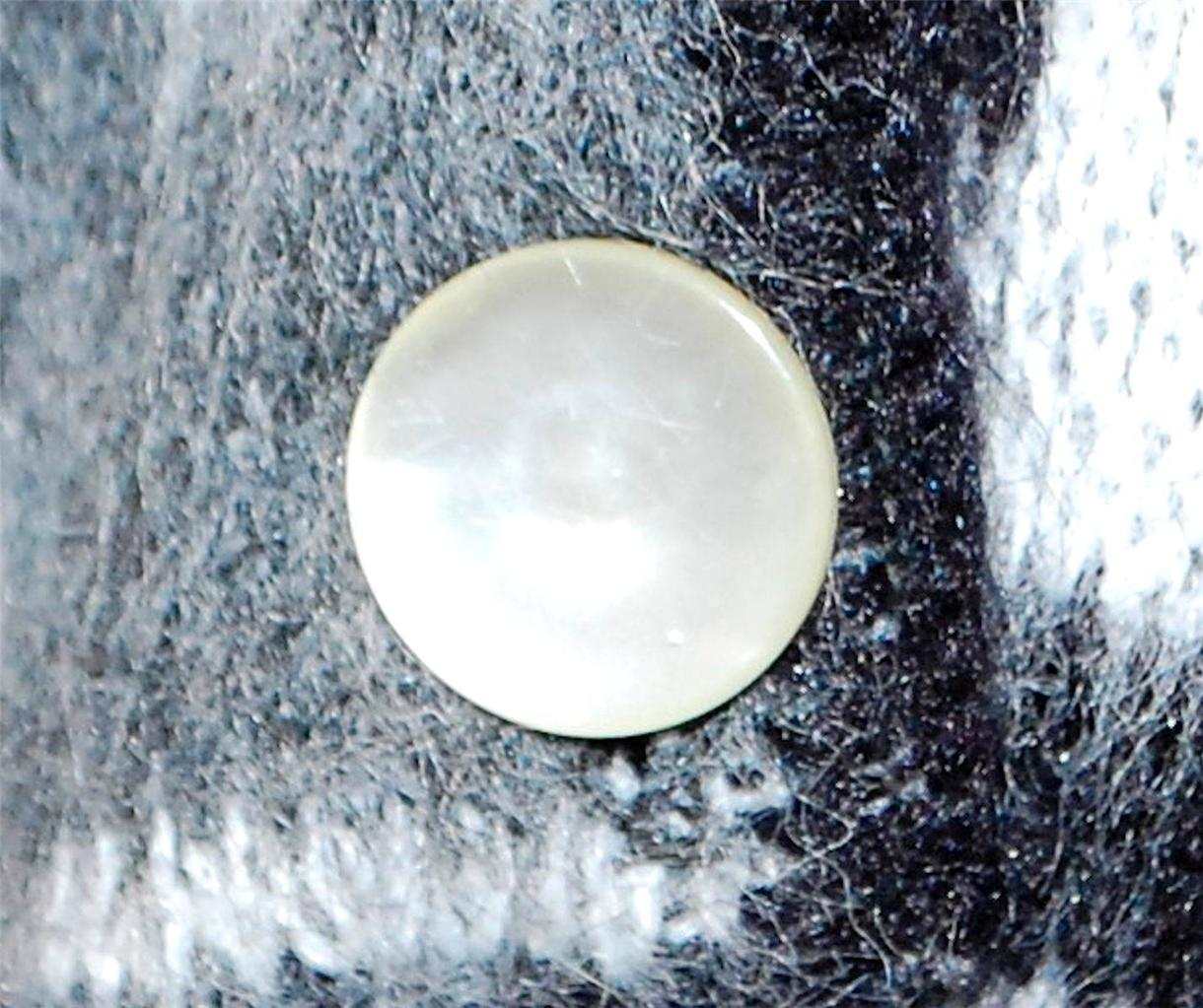 Close-up of button on black, white, and grey faux mohair woman's retro Mad Men's era cardigan sweater with psychedelic swirl design
