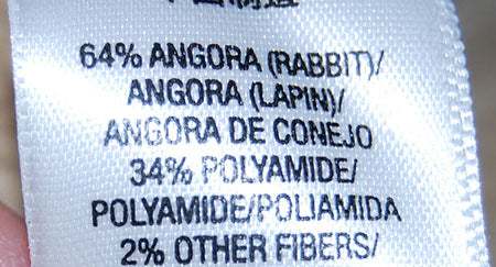 Close-up of Juicy Couture Two-Tone Angora Sweater fabric label showing 64% angora and 34% polyamide content