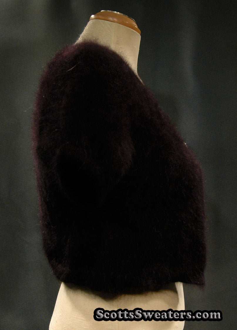 Woman's angora shrug cardigan sweater with jeweled rhinestone button by Express displayed on a mannequin