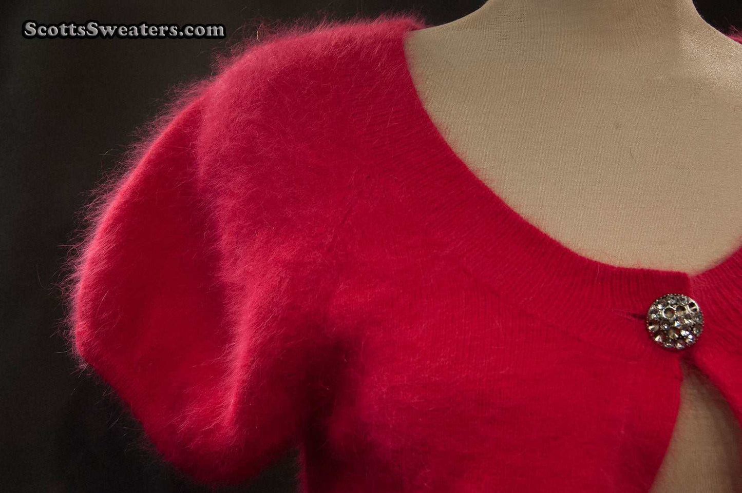 Red woman's angora shrug with jeweled rhinestone button by Express on mannequin